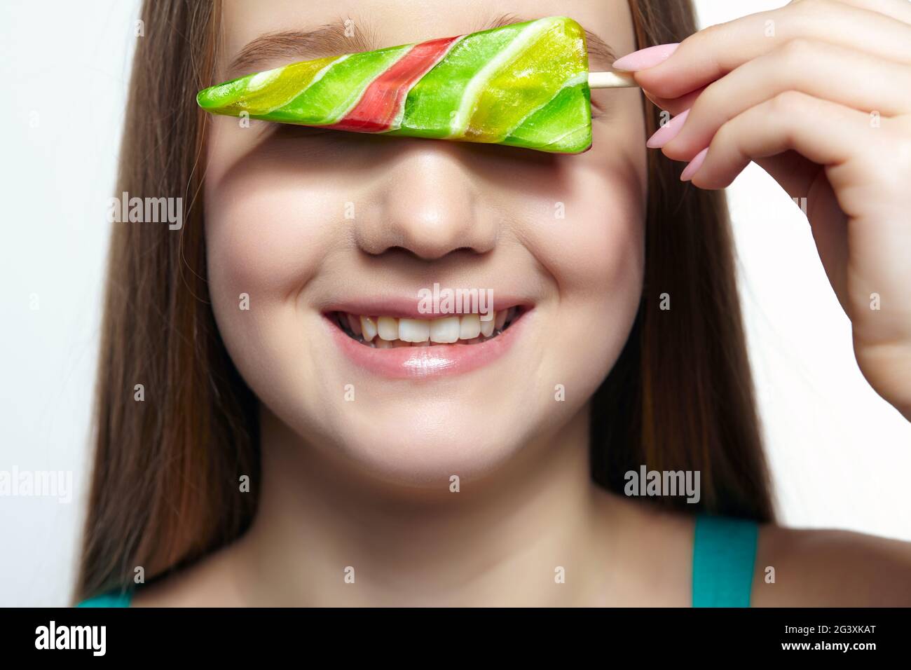 Teenager-Mädchen mit Lutscher in den Händen Augen schließen und lächeln. „Sweet Tooth“-Konzept Stockfoto