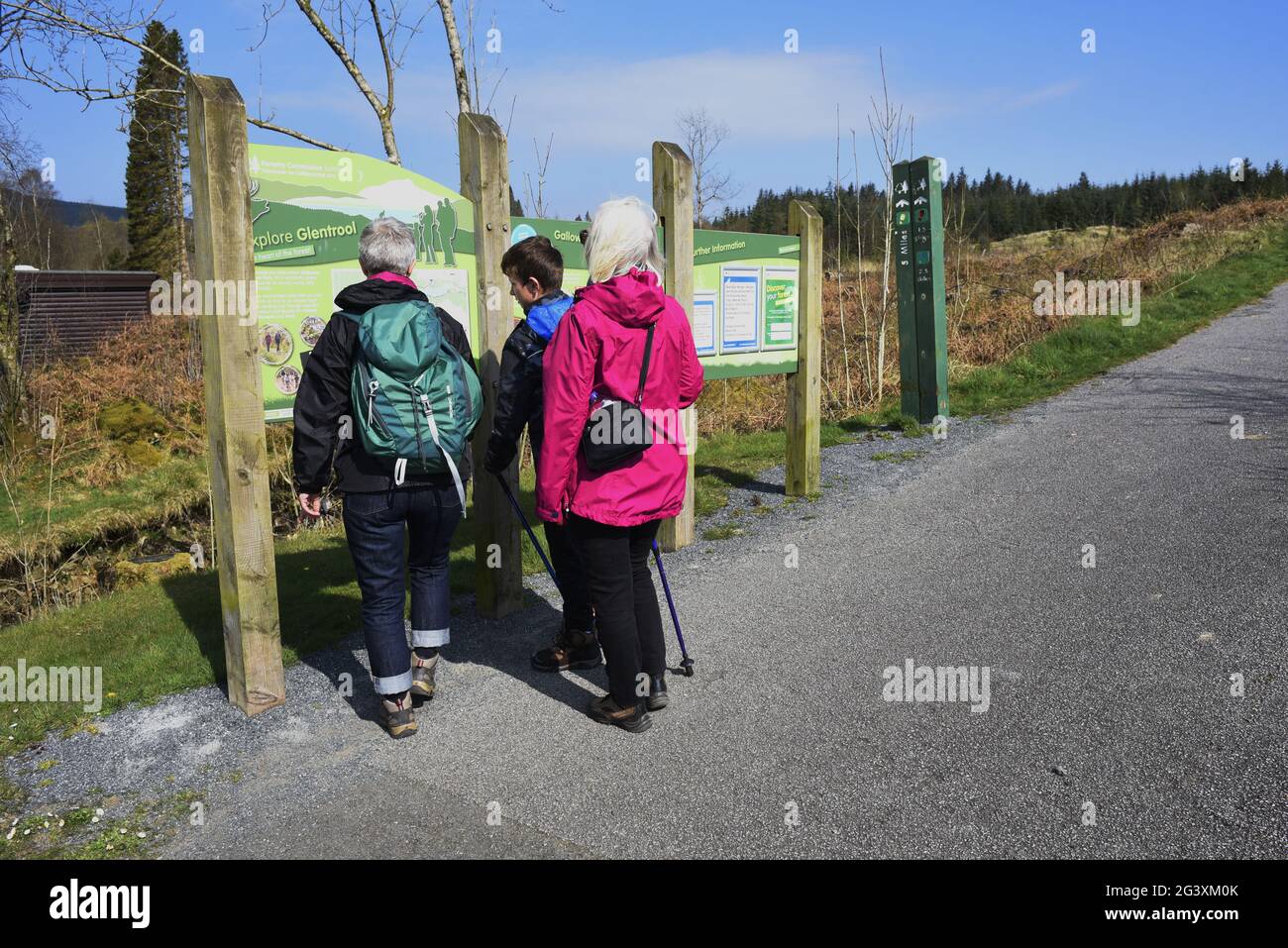 Glentrool Forest Park, Glentrool, Newton Stewart DG8 6SZ. Drei Generationen einer Familie, die kurz vor einem Spaziergang steht, um eine Reihe von Karten und Noticeboa zu sehen Stockfoto