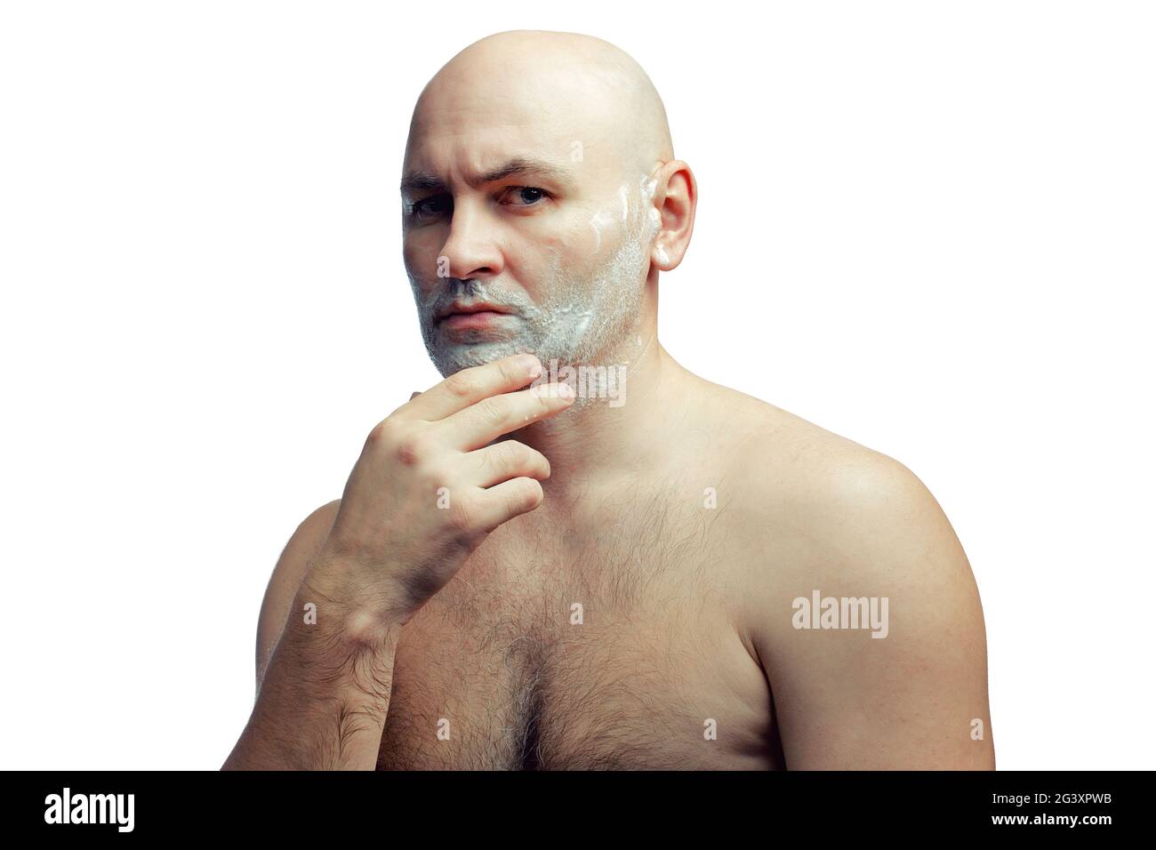 Ein kahlköpfiger weißer Mann bereitet sich darauf vor, seine Stoppeln zu rasieren. Ein Männergesicht mit Rasierschaum. Stockfoto