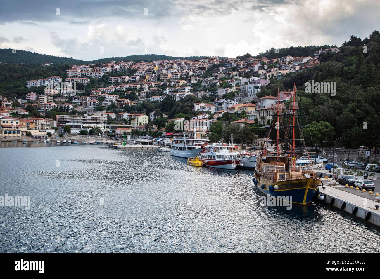 Ausflugsboote auf dem Pier mit Stadt dahinter, Rabac, Istrien, Kroatien, Europa Stockfoto