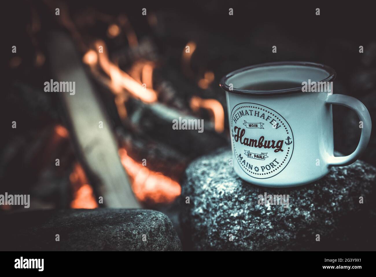 Tasse Tee mit Hamburg-Schriftzug vor dem Holzfeuer, Hamburg, Deutschland Stockfoto