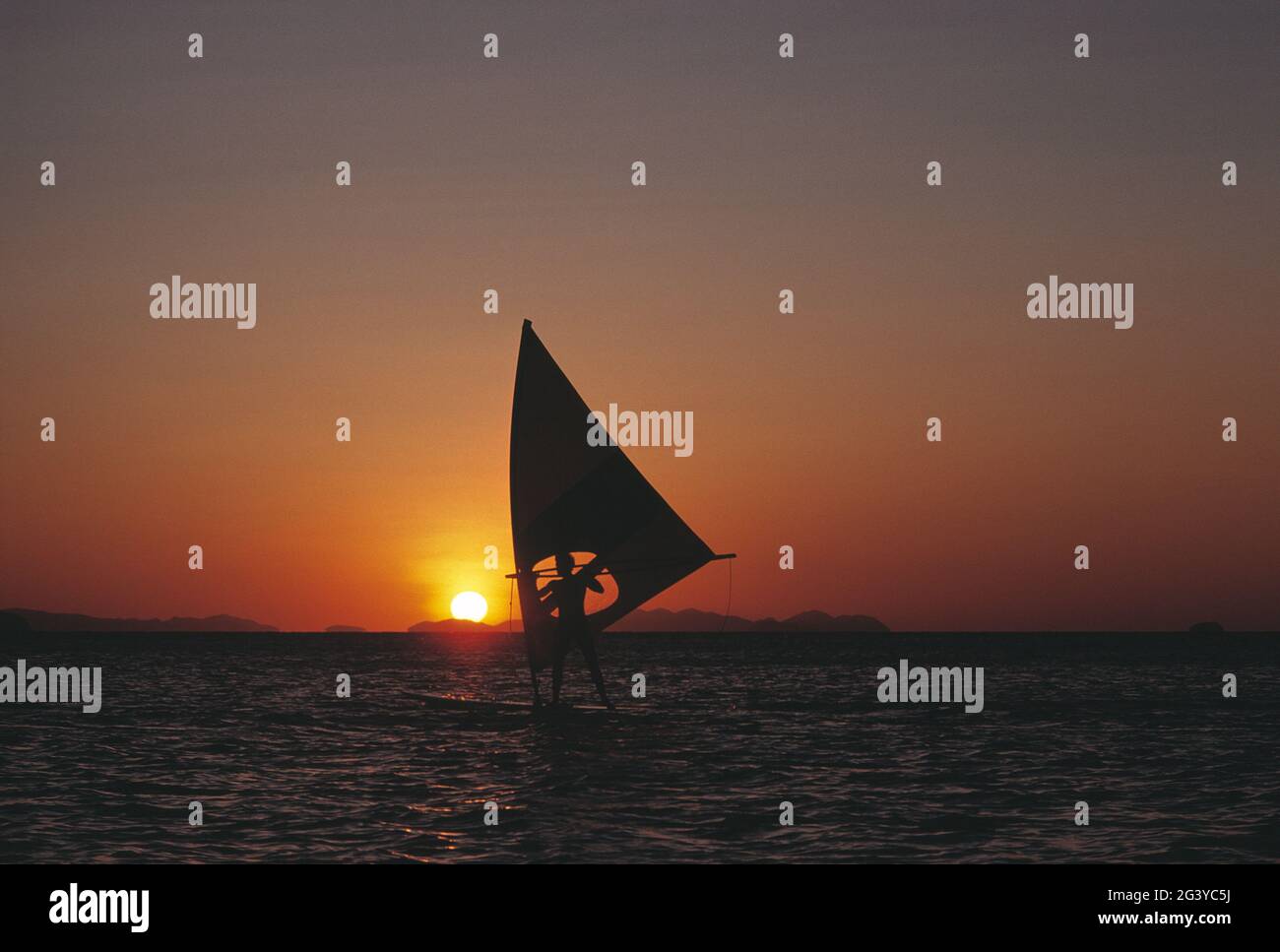 Australien. Queensland. Whitsunday Islands. Mann beim Windsurfen bei Sonnenuntergang. Stockfoto