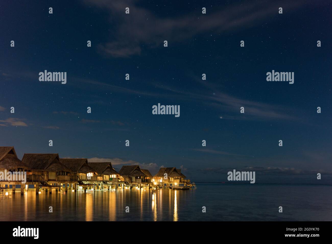 Überwasserbungalows des Sofitel Ia Ora Beach Resort in der Lagune von Moorea mit dem Kreuz des Südens am Sternenhimmel in der Nacht, Moorea, Windward is Stockfoto