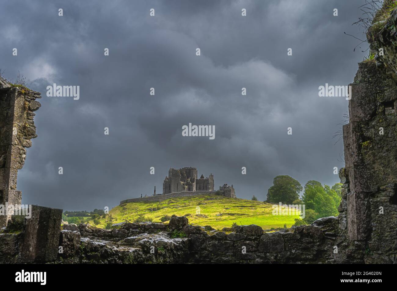 Blick durch die alten Ruinen der Hore Abbey Mauern auf der Burg Rock of Cashel mit dunklem, dramatischem Sturmhimmel Stockfoto