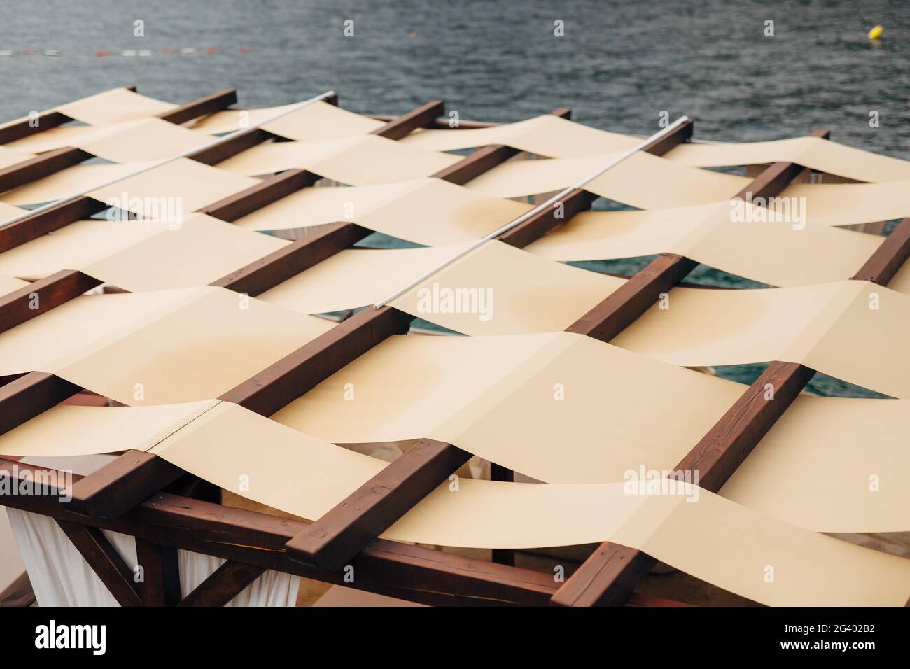 Ungewöhnlicher Dachverschluss. Das Dach des Restaurants auf der Straße am Meer. Stoffdach Stockfoto