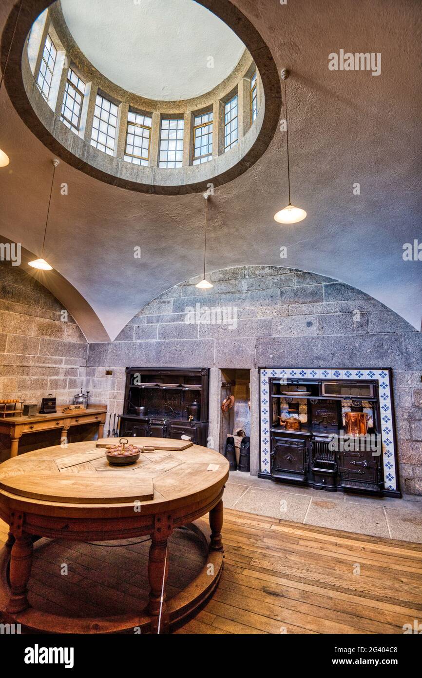 Ein von Sir Edwin Lutyens entworfenes, gewölbtes Laternenfenster beleuchtet einen runden Beechwood-Tisch in der Küche der 20er Jahre von Castle Drogo, Devon, Großbritannien Stockfoto