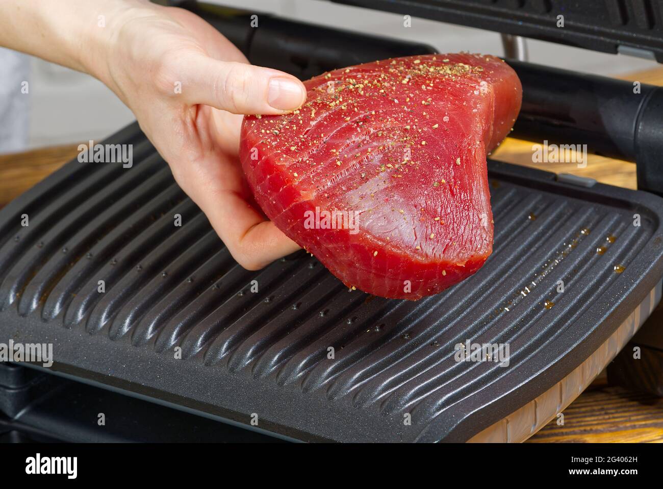 Rohe Thunfisch-Steaks auf elektrischem Grill. Stockfoto