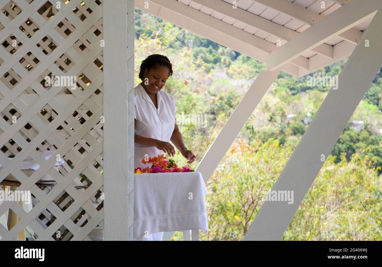 Spa-Therapeut bereitet Blumen in einer weißen Cabana zu. St. Lucia, Westindien. Stockfoto