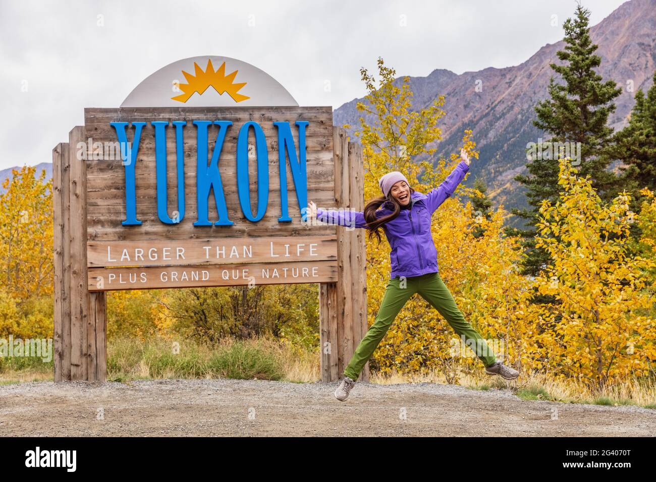 Yukon Territory Willkommensschild - fröhliche Touristenfrau, die in kanadischen Territorien Spaß macht. Alaska Kreuzfahrt Urlaub Herbst. Stockfoto