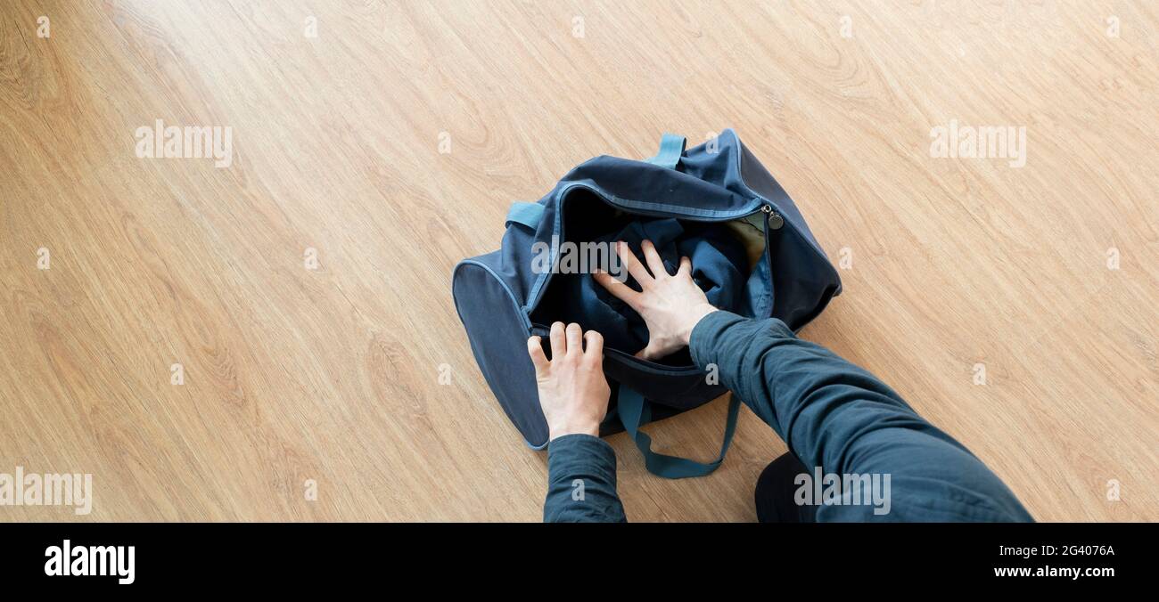 Überkopfansicht der Person, die Dinge vor Reiseantritt in die Tasche packt Stockfoto