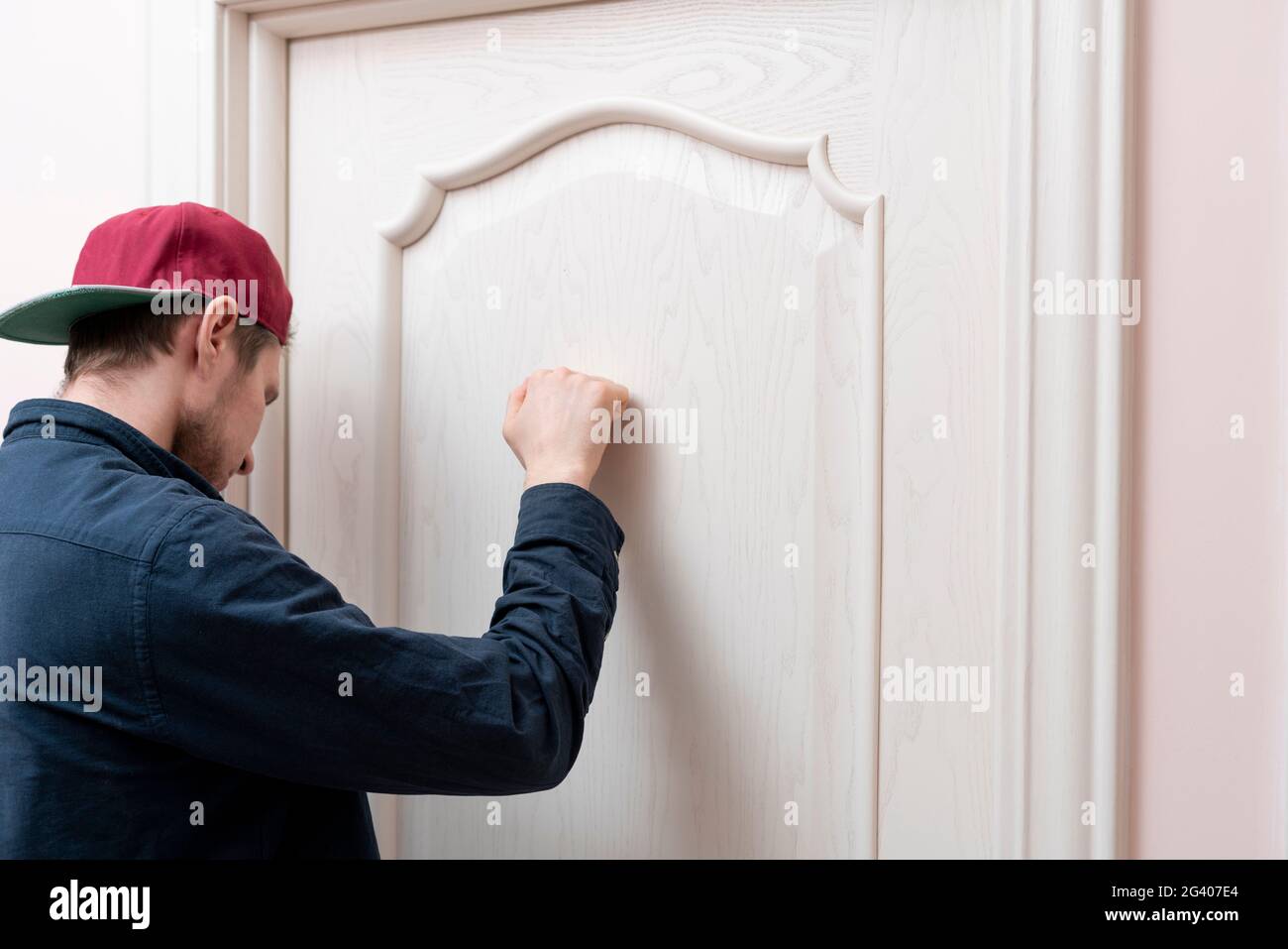 Person klopft an die Tür, besucht das Haus der Freunde Stockfoto