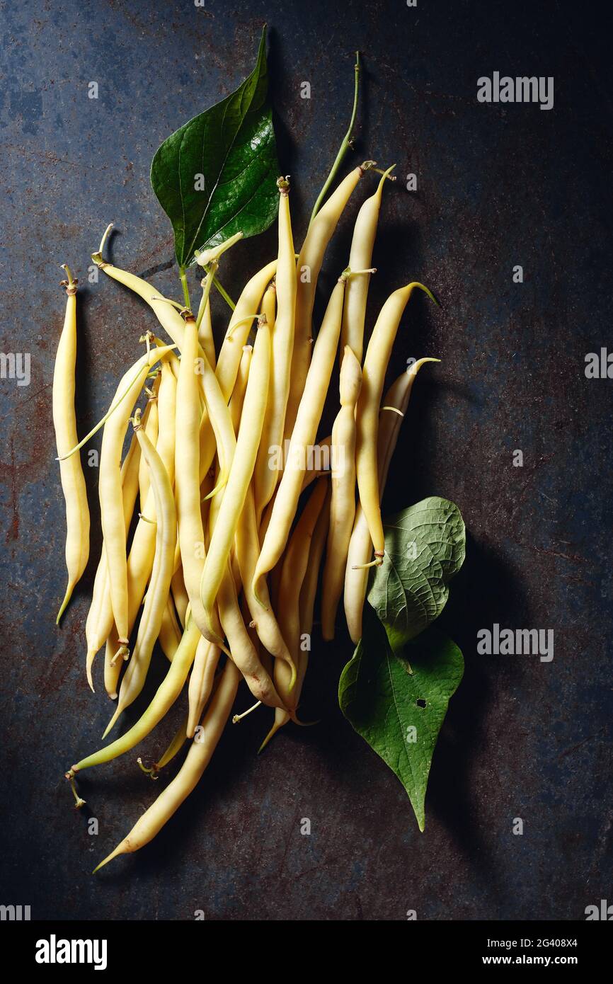 Gelbe Wachsbohnen auf dunkelblauem Hintergrund, Draufsicht. Stockfoto