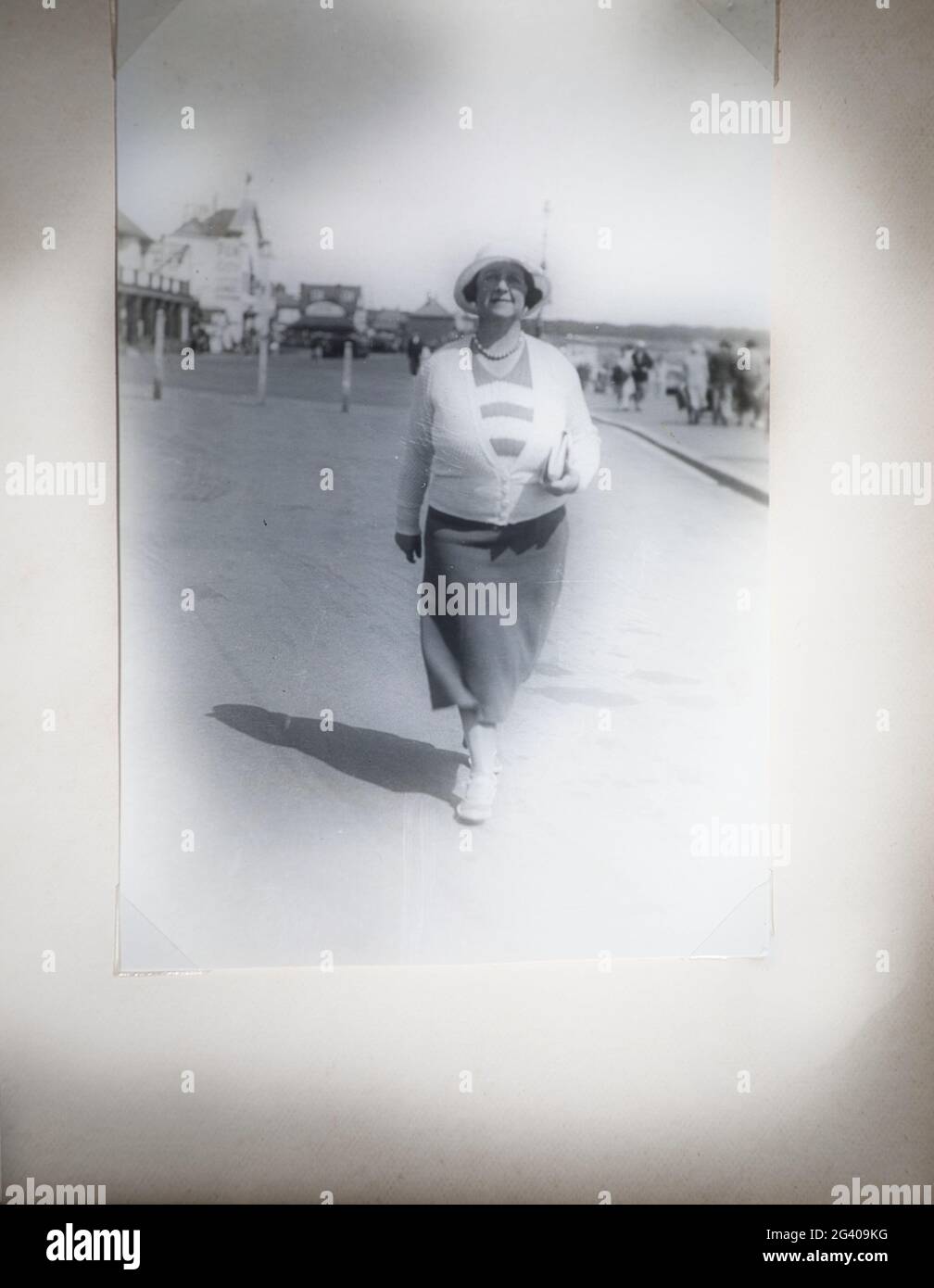 Authentisches Vintage-Foto der 30er Jahre von einer Frau mittleren Erwachsenen in einem Hut, der allein geht, Bridlington, East Yorkshire, England. Konzept der Nostalgie, altmodisch Stockfoto