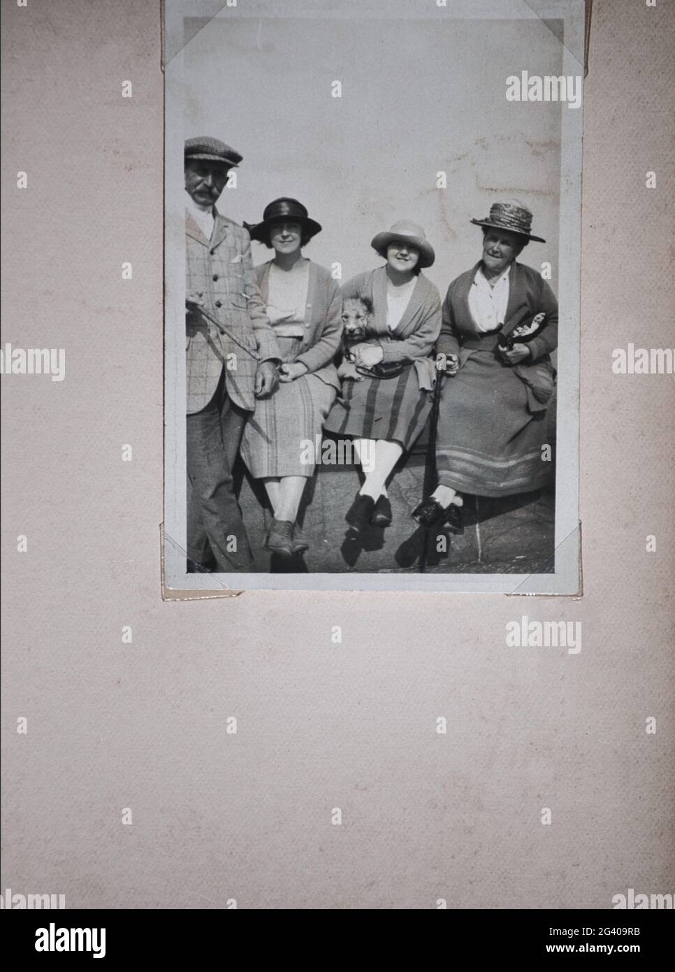 Authentisches Vintage-Foto aus den 1920er Jahren von älteren Männern und Frauen und zwei jungen Frauen, die alle Hüte tragen. Konzept von Nostalgie, Vintage, Stockfoto
