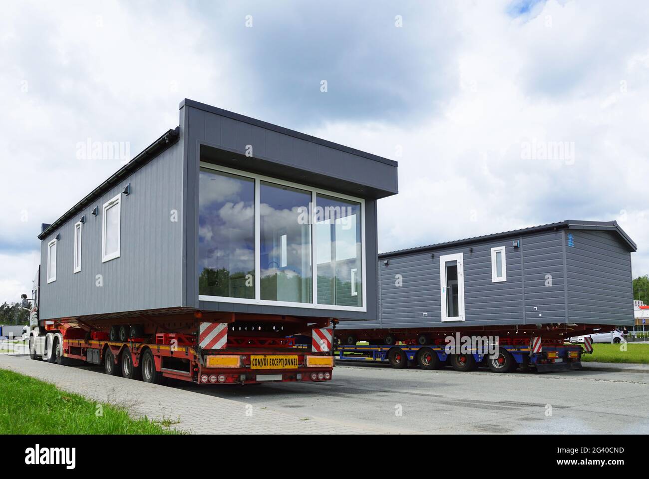 Ein sehr langes und breites Fahrzeug. Übergroße Ladung oder außergewöhnlicher Konvoi. Ein LKW mit einem speziellen Sattelauflieger für den Transport von überdimensionaler Ladung - transp Stockfoto