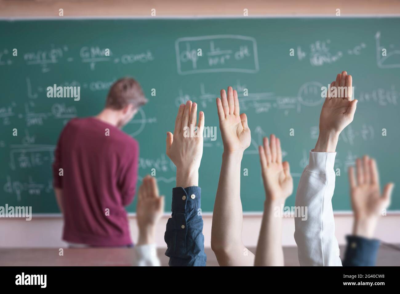 Schüler in der Schule mit erhobenen Händen? Gemeinsam lernen Stockfoto