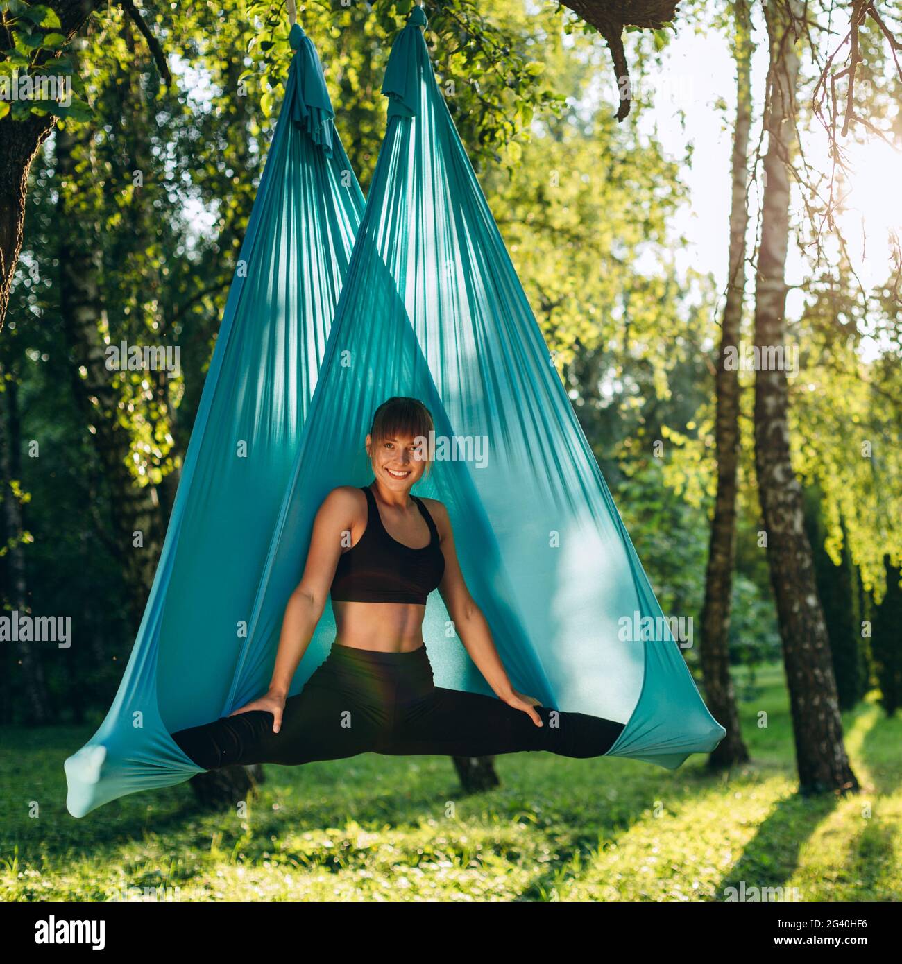 Teen mit Zöpfen macht Beine im Fitnessraum breit Teen mit Zöpfen macht Beine im Fitnessraum breit