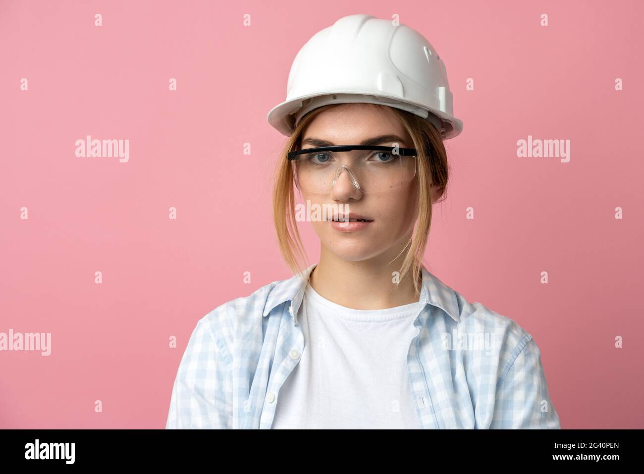 Junges Mädchen in einem Bauhelm auf einem Hintergrund einer rosa Wand.  Schönes Mädchen in Baubrille und Helm isoliert auf einer rosa Wand  Stockfotografie - Alamy