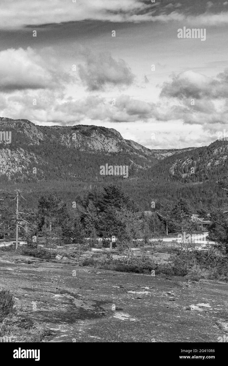 Schwarz-Weiß-Bild des Morgenaufgangs mit Nebelwolken und Bergen in der Naturlandschaft Treungen in Nissedal Norwegen. Stockfoto