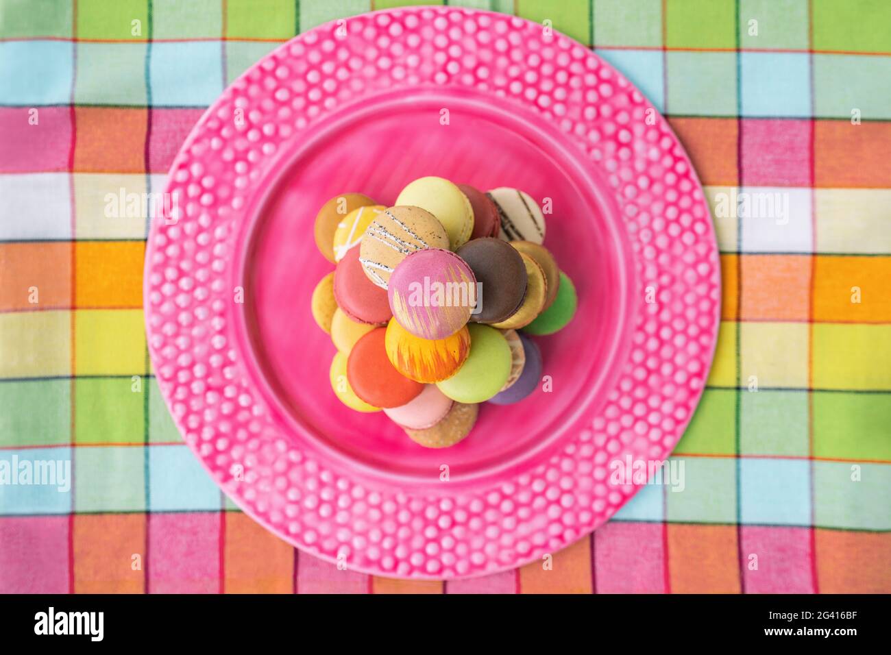 Macarons Turm auf rosa Dessertplatte Draufsicht. Retro rosa vintage Tischdecke Ostern Tisch Wohnküche. Sortiment von Pastellfarben Macaron Stockfoto