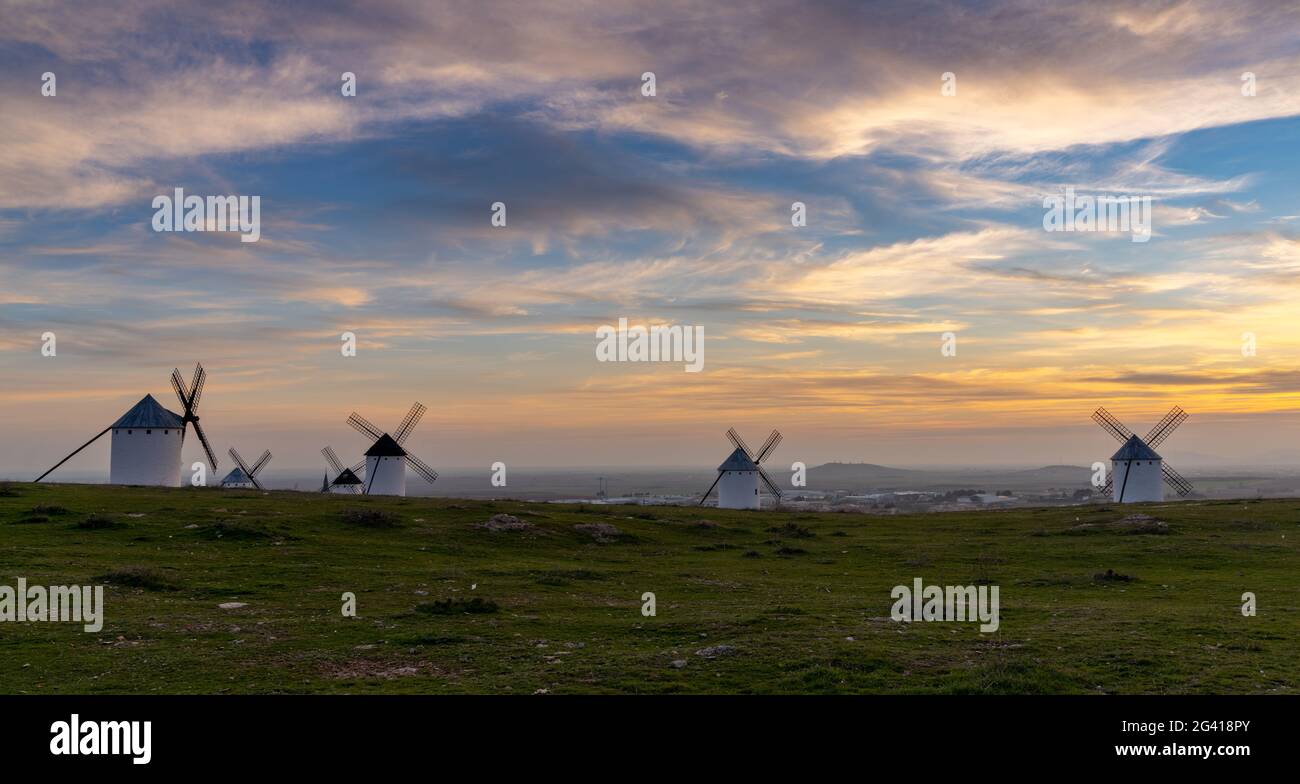 Blick auf die historischen weißen Windmühlen von La Mancha oberhalb der Stadt Campo de Criptana bei Sonnenuntergang Stockfoto