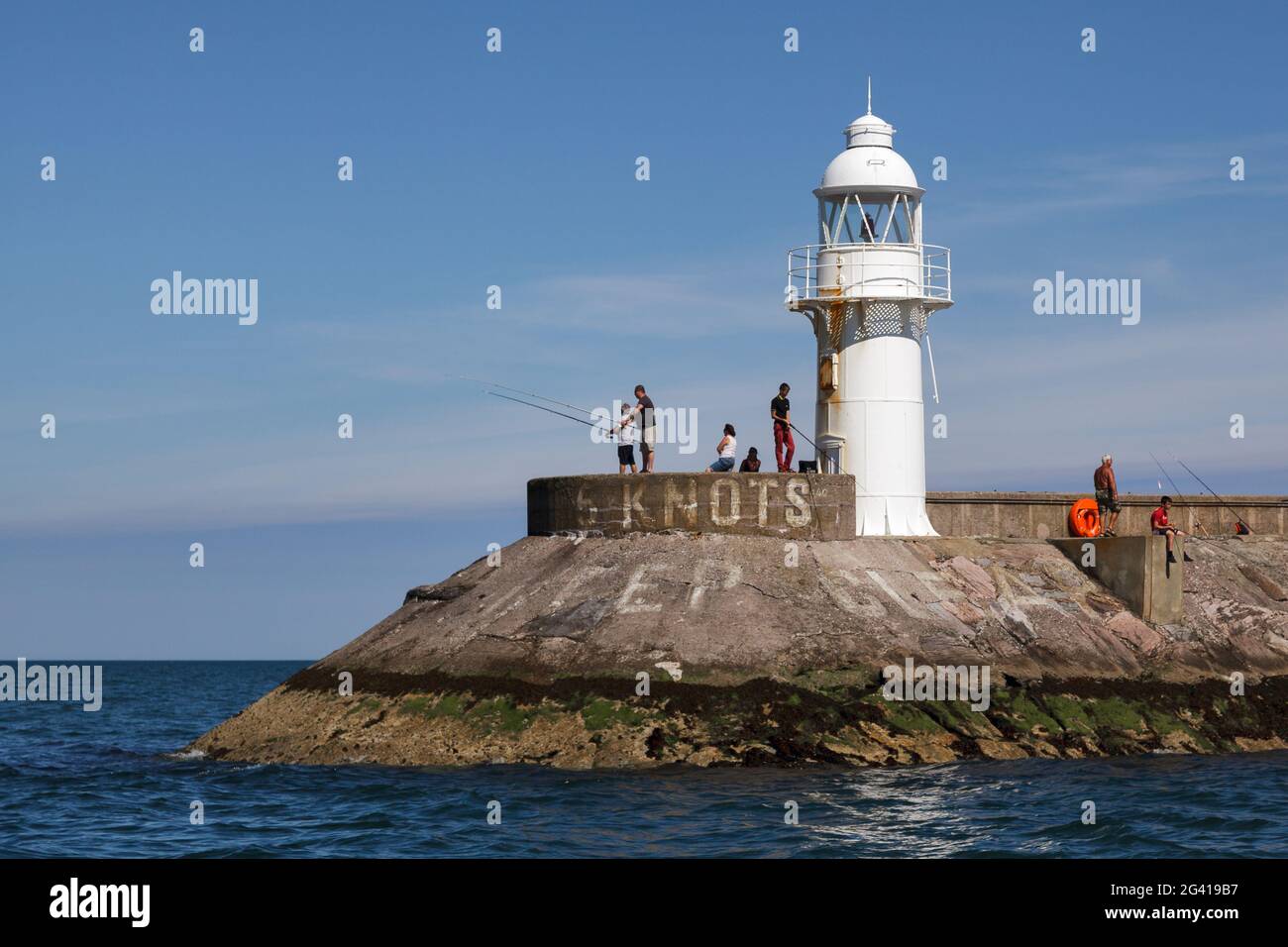 BRIXHAM, DEVON/UK - JULI 28 : Menschen, die am 28. Juli 2012 in der Nähe des Leuchtturms am Hafen von Brixham in Devon angeln. Nicht identifiziertes Peop Stockfoto