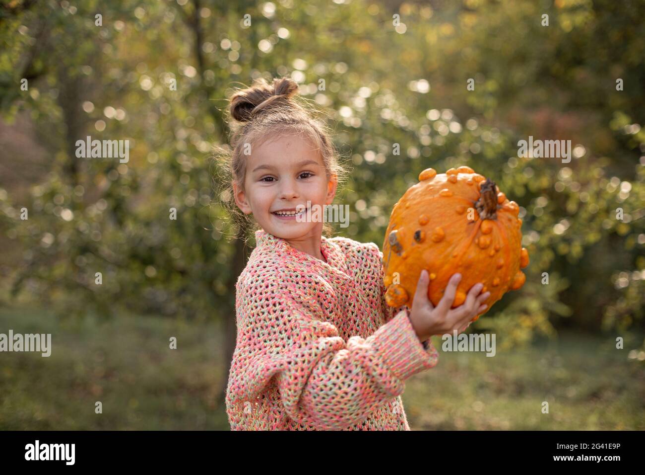 Deformierte hässliche orange Kürbis in einem Kind Hände. Stockfoto