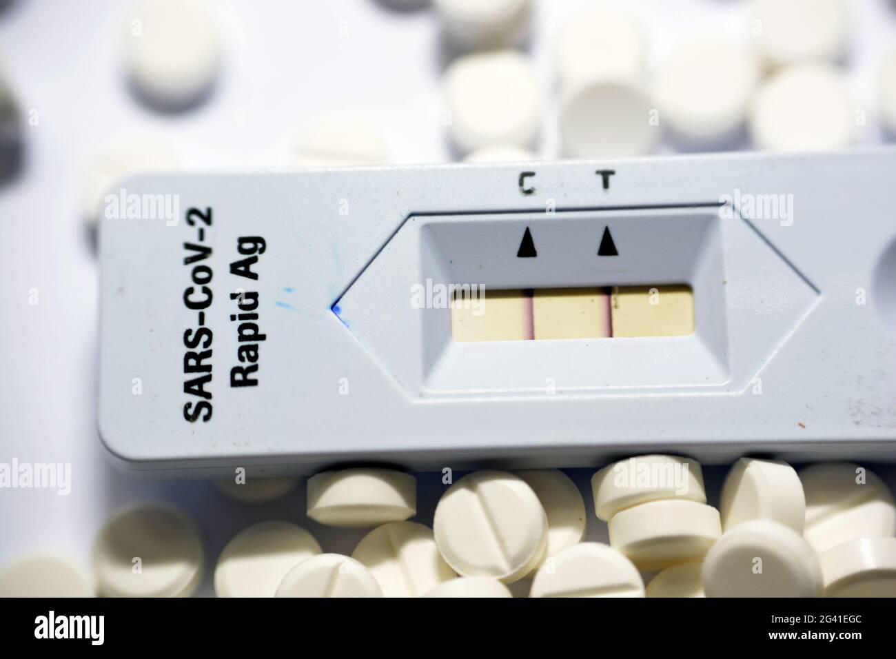 Ein positives Ergebnis des SARS-COV-2 Rapid AG-Tests, ein positiver Covid-19-Corona-Virus-Test mit weißen Tabletten, medikamentöse Behandlung isoliert auf Weiß Stockfoto