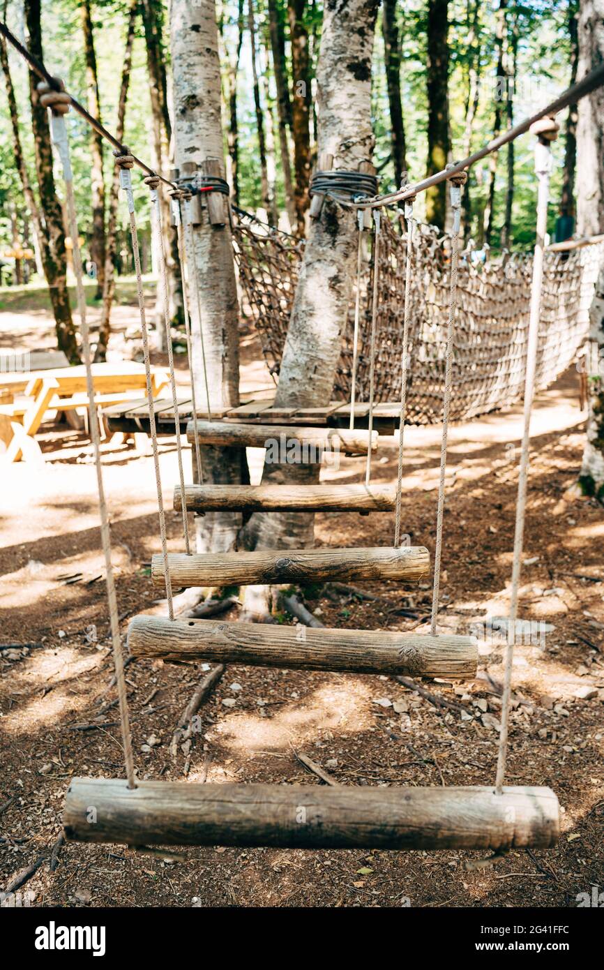 Kletterpark hoch in den Bäumen. Hindernisparcours im Vergnügungspark. Sportliche Aktivitäten im Freien. Herausforderung Abenteuer Solo Sport. Hig Stockfoto