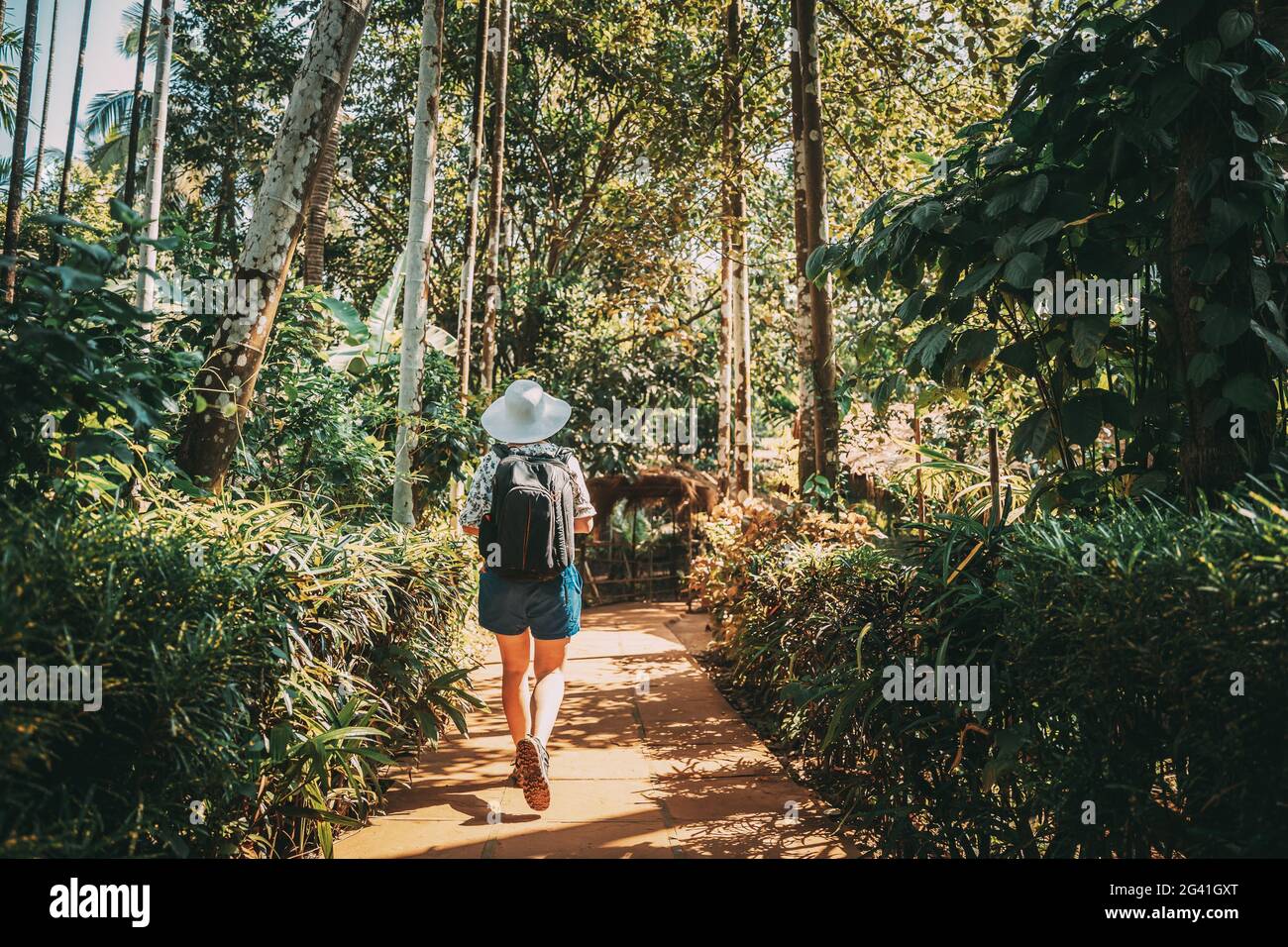 Goa, Indien. Junge Backpacker-Frau Beim Sonnentag Durch Den Botanischen Garten Stockfoto