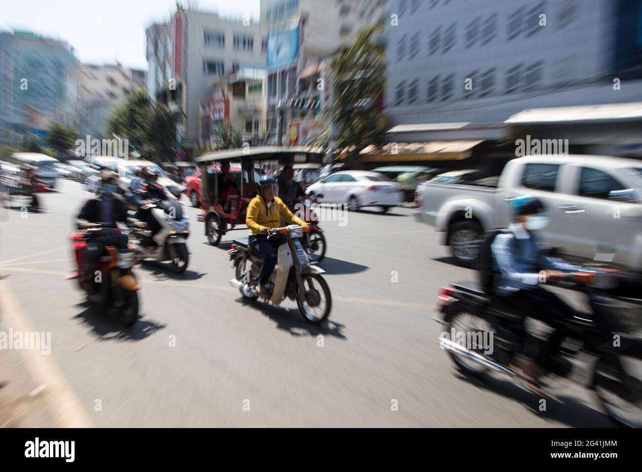 Vergrößertes Bild von Menschen auf Mopeds und Tuk-Tuk auf belebten Straßen, Phnom Penh, Kambodscha, Asien Stockfoto