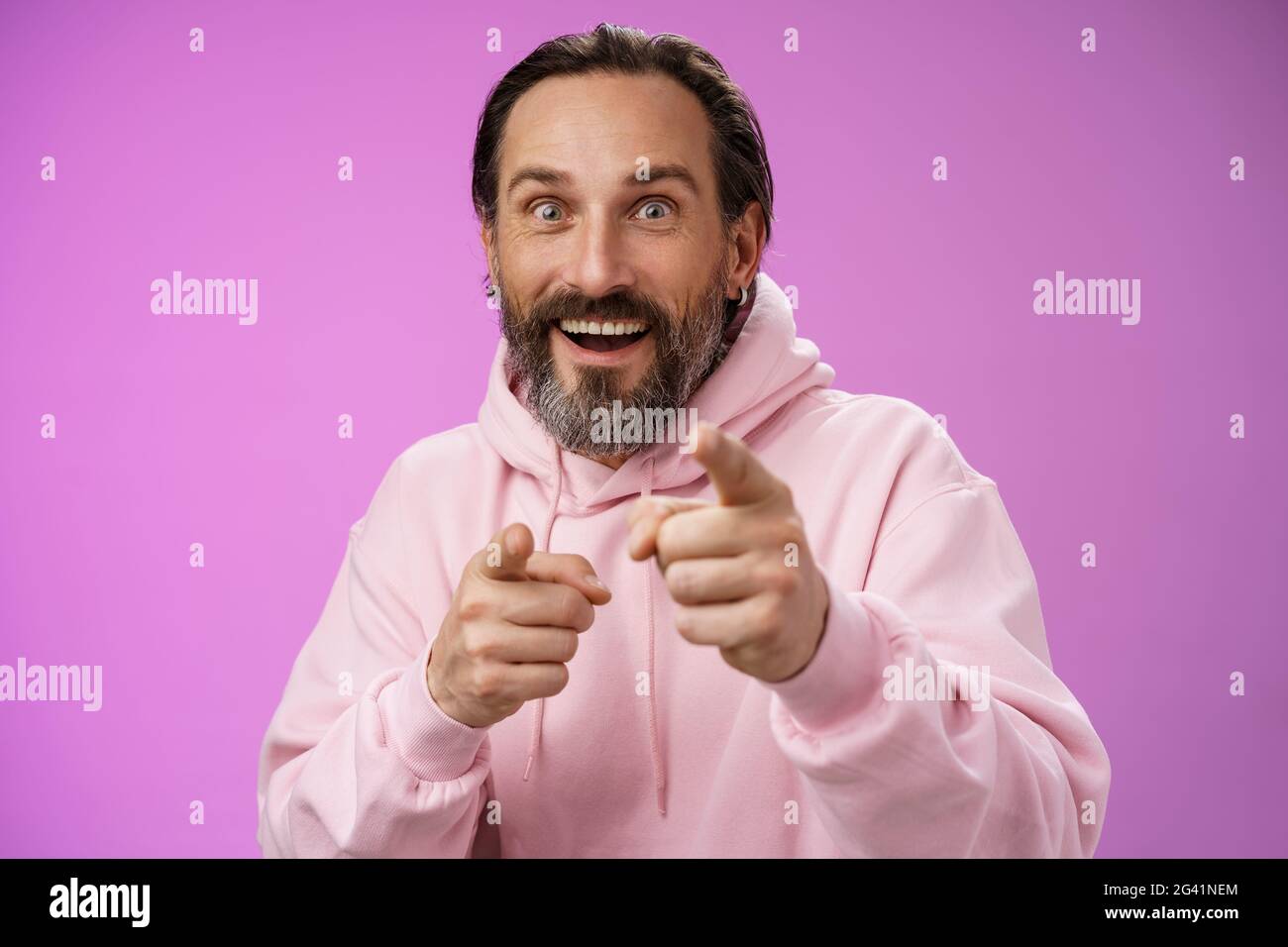 Begeistert erregt charismatisch glücklich glücklich Erwachsene schöner bärtiger Mann zeigen Kamera lächelnd weiten Augen Blick beeindruckt sehen fa Stockfoto