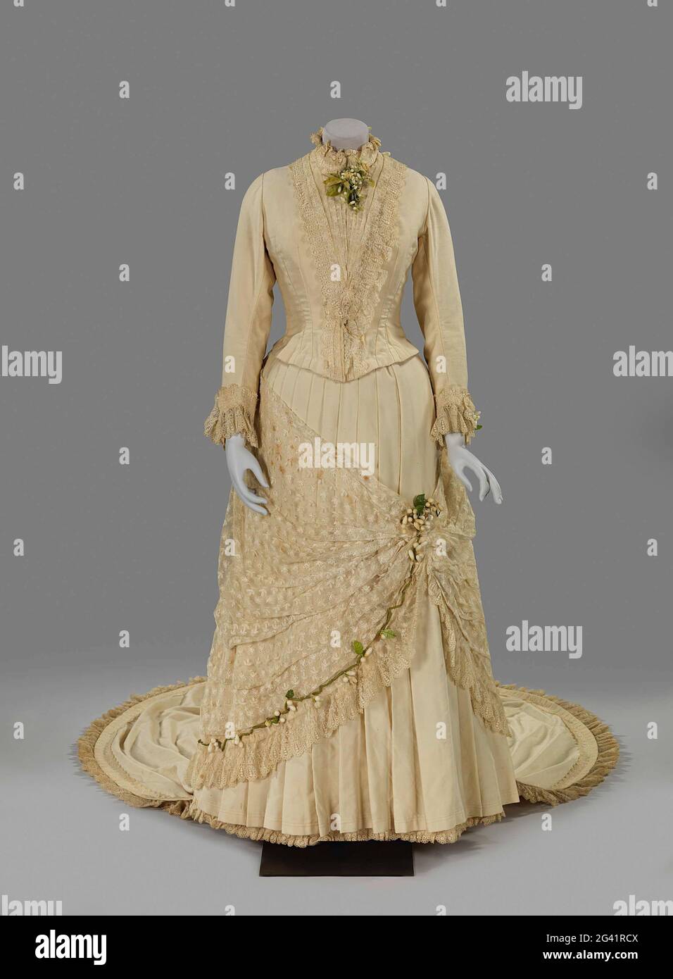 Hochzeitskleid mit Orangenblüte. Symbolik spielt eine wichtige Rolle bei der Dekoration für eine Hochzeit. Ab dem 19. Jahrhundert stand ein weißes Hochzeitskleid für Jungfräulichkeit, Reinheit und Unschuld. Orangenblüte brachte Glück und Keuschheit und galt nach der zeitgenössischen Etikette als unverzichtbar. Die Bräute integrierten daher Orangenblüten, entweder real oder aus Wachs, in ihre Haare, auf ihr Kleid oder in ihren Hochzeitsstrauß. In diesem Fall schmücken orangefarbene Blüten aus Wachs das Kleid. Stockfoto Hochzeitskleid mit Orangenblüte. Symbolik spielt eine wichtige Rolle bei der Dekoration für eine Hochzeit. Ab dem 19. Jahrhundert stand ein weißes Hochzeitskleid für Jungfräulichkeit, Reinheit und Unschuld. Orangenblüte brachte Glück und Keuschheit und galt nach der zeitgenössischen Etikette als unverzichtbar. Die Bräute integrierten daher Orangenblüten, entweder real oder aus Wachs, in ihre Haare, auf ihr Kleid oder in ihren Hochzeitsstrauß. In diesem Fall schmücken orangefarbene Blüten aus Wachs das Kleid. Stockfoto
