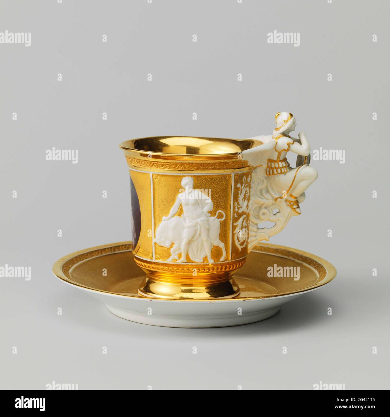 Tasse und Untertasse mit Porträts von Philips, Graf von Flandern und Maria van Hohenzollern-Sigmaringen. Tasse und Untertasse aus Porzellan. Der Kopf ist bunt bemalt mit den Porträts von Philips, dem Grafen von Flandern und seiner Frau Maria von Hohenzollern-Sigmaringen. Zusätzlich zu den Porträts auf den Köpfen in Keksrelief Hercules (?) Mit dem Löwen und Europa (?) Mit dem Stier. Die Ohren in Form einer geflügelten Figur in Keks, die ein glasiertes Wappen auf dem Schuss mit gekrönten Bündnisarmen des Paares und der sinnvollen Nichte ohne Gott hält. Auf der Schüssel in der Mitte das gekrönte Monogramm Stockfoto