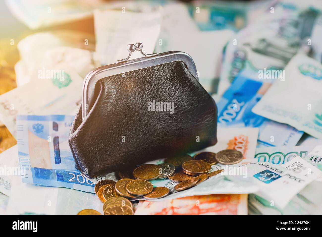 Eine alte schwarze Brieftasche sitzt auf einem Haufen russischen Geldes. Finanzielle Einsparungen. Stockfoto