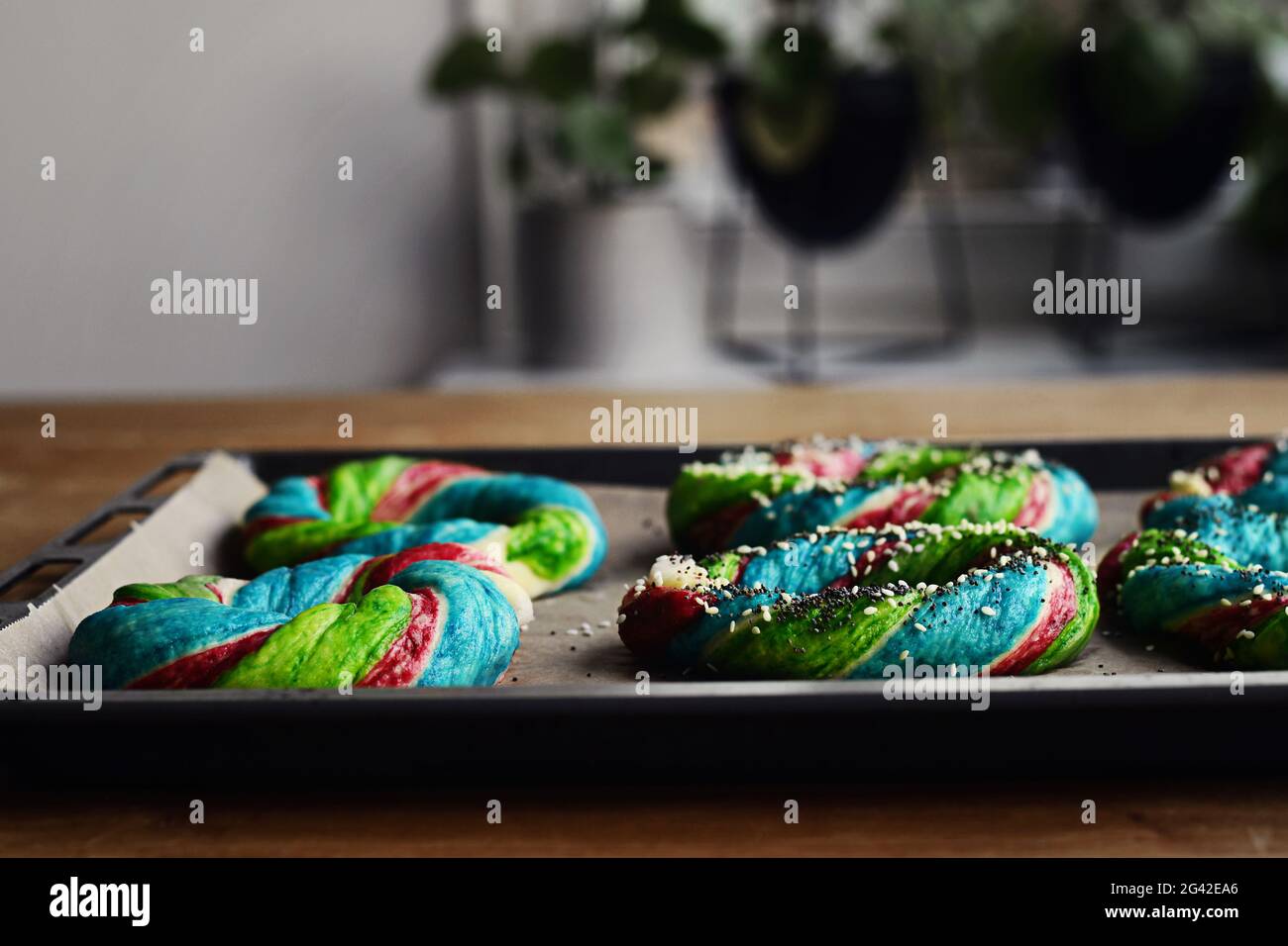 Bagels im Rainbow-Stil auf einem Tablett. Selbst gebackenes, farbenfrohes Frühstücksbrot. Stockfoto