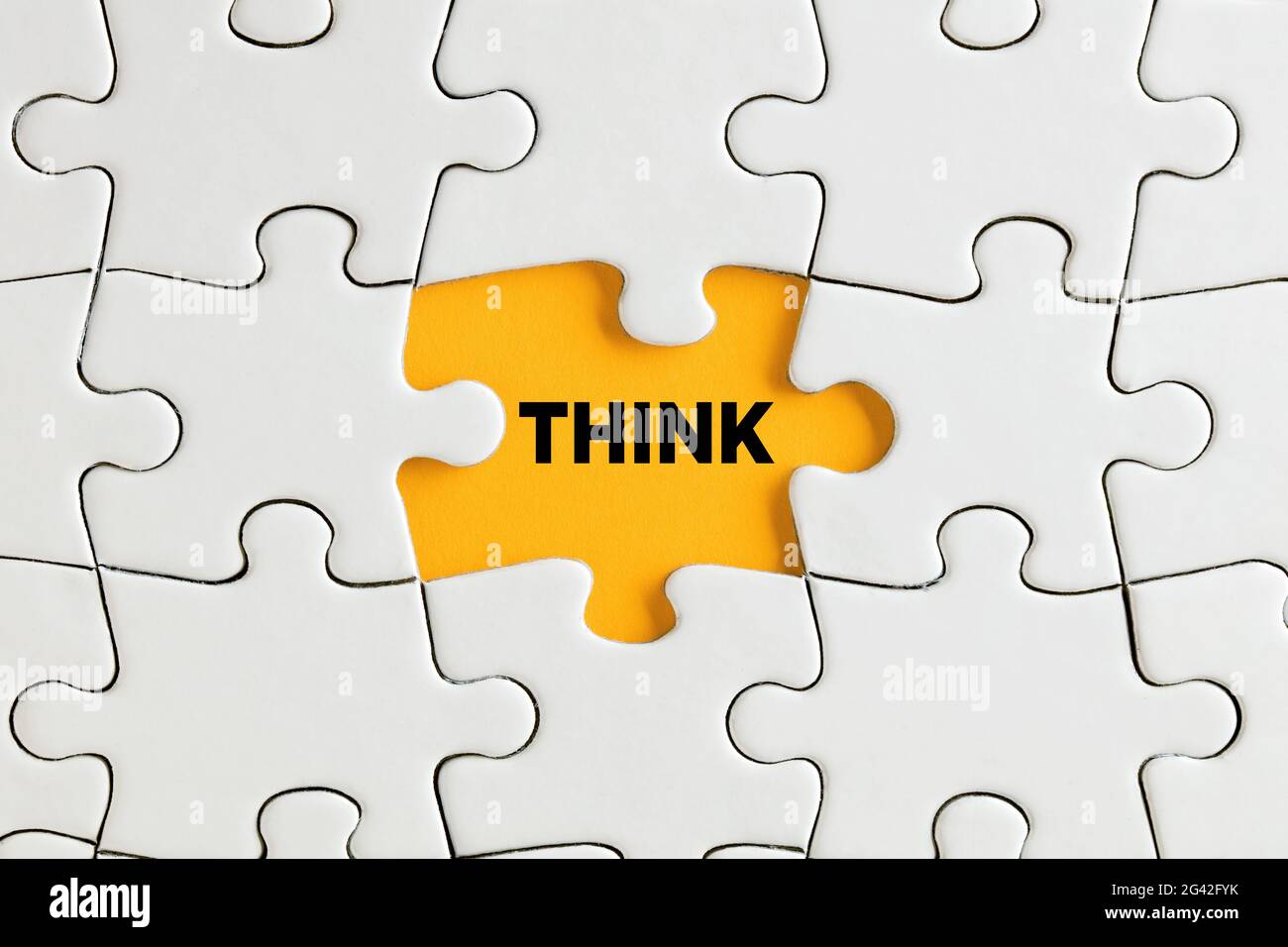 Das Wort think steht auf einem gelben fehlenden Puzzleteil. Denken Sie an ein kreatives Lösungskonzept. Stockfoto