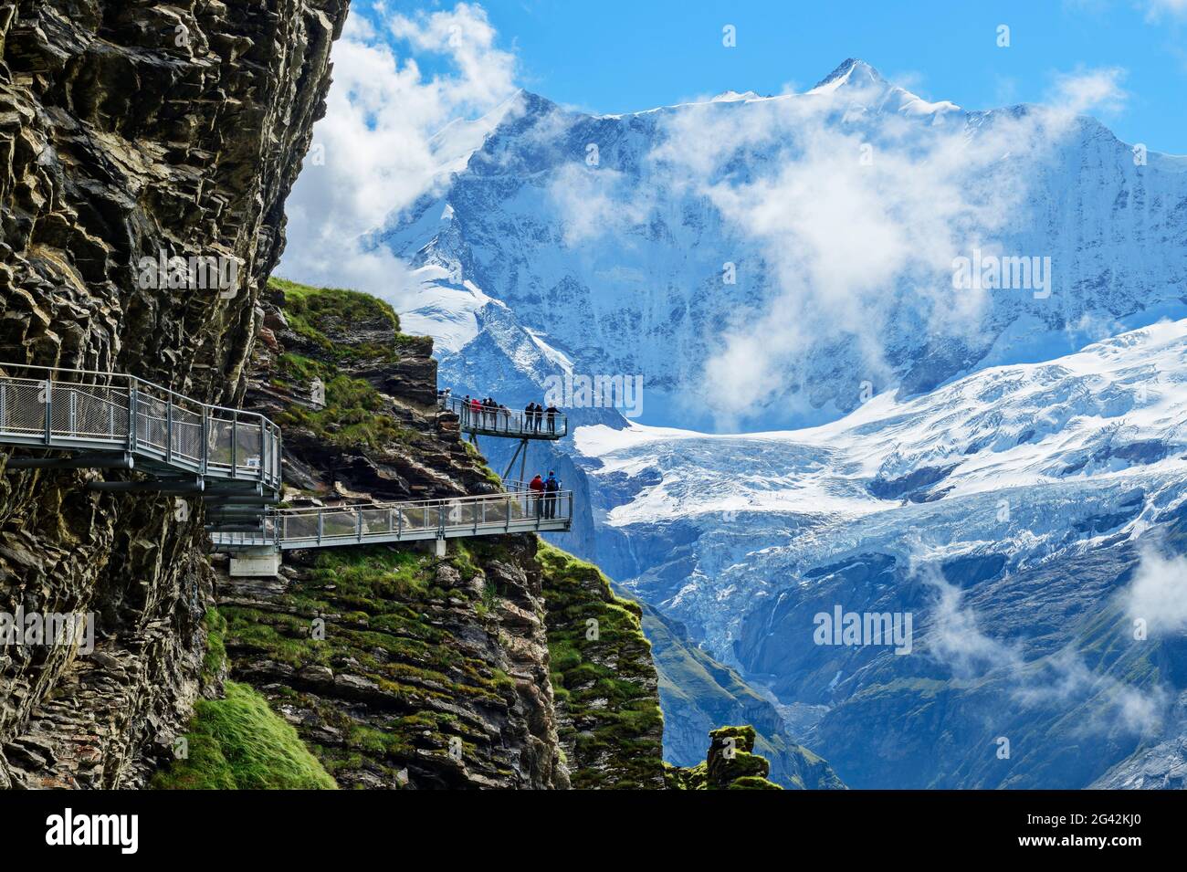 Mehrere Menschen stehen auf dem Cliff Walk mit Blick auf Fiescherhorn, Tissot Cliff Walk, First, Grindelwald, Berner Oberland, UNESCO-Welterbe Stockfoto