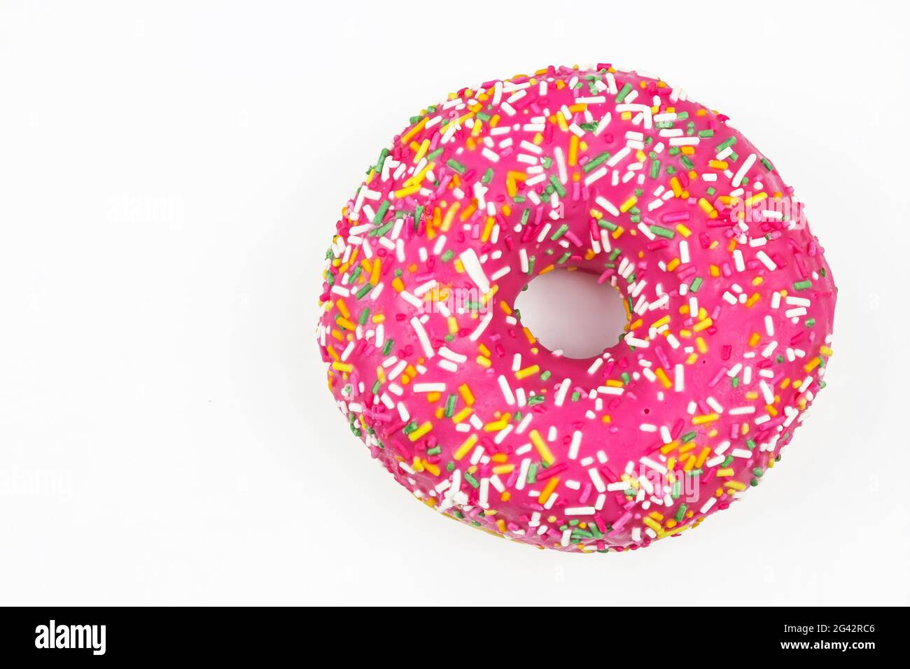 Rosa Donut mit bunten Streuseln verziert. Flach liegend. Draufsicht. Stockfoto