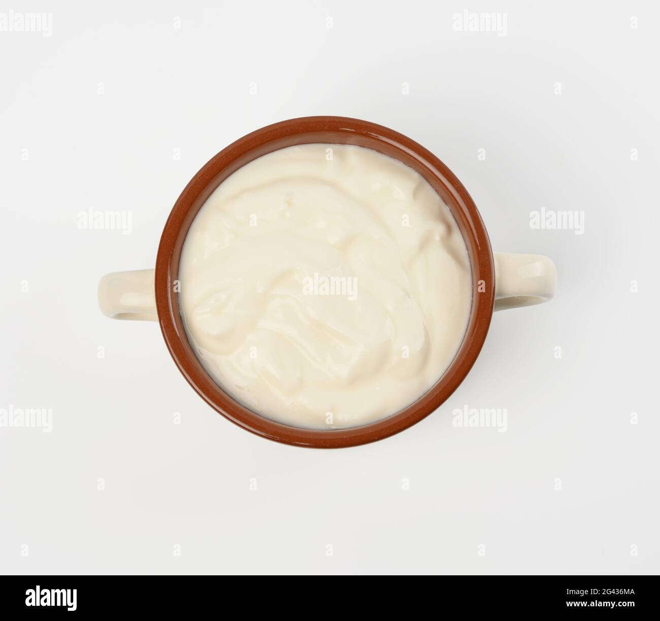 Saure Rahm in einer braunen Keramikschale auf weißem Hintergrund, fermentiertes Milchprodukt Stockfoto
