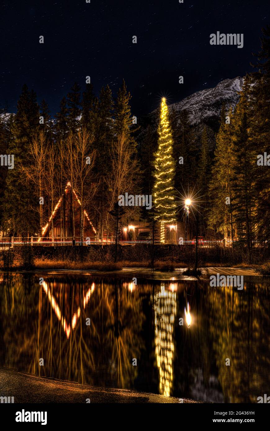 Weihnachtslichter spiegeln sich in River at Night, Alberta, Kanada Stockfoto