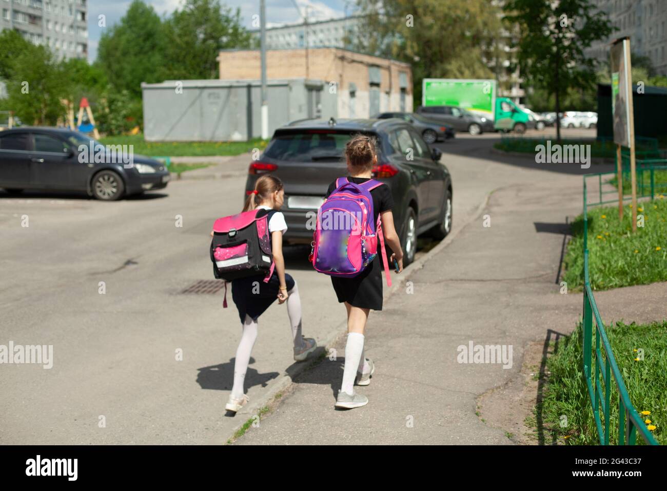 Zwei Schülerinnen gehen mit Rucksäcken nach Hause. Die