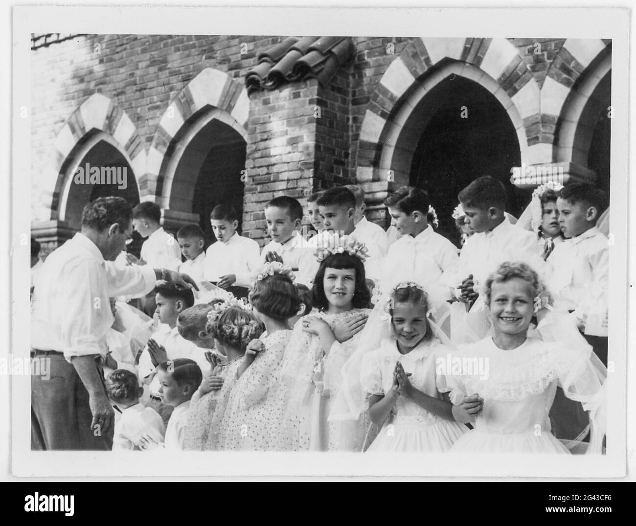 Jungen und Mädchen vor einer katholischen Kirche bei ihrer ersten Heiligen Kommunion, 1958, USA Stockfoto