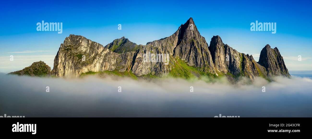 Landschaft mit Kongen-Bergen, die über Nebel aufsteigen, Fjordgard, Senja, Norwegen Stockfoto