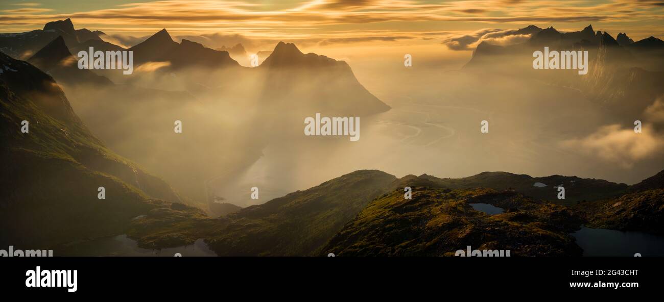 Berge und Fjord im Nebel bei Sonnenaufgang, Mefjorden, Senja, Norwegen Stockfoto