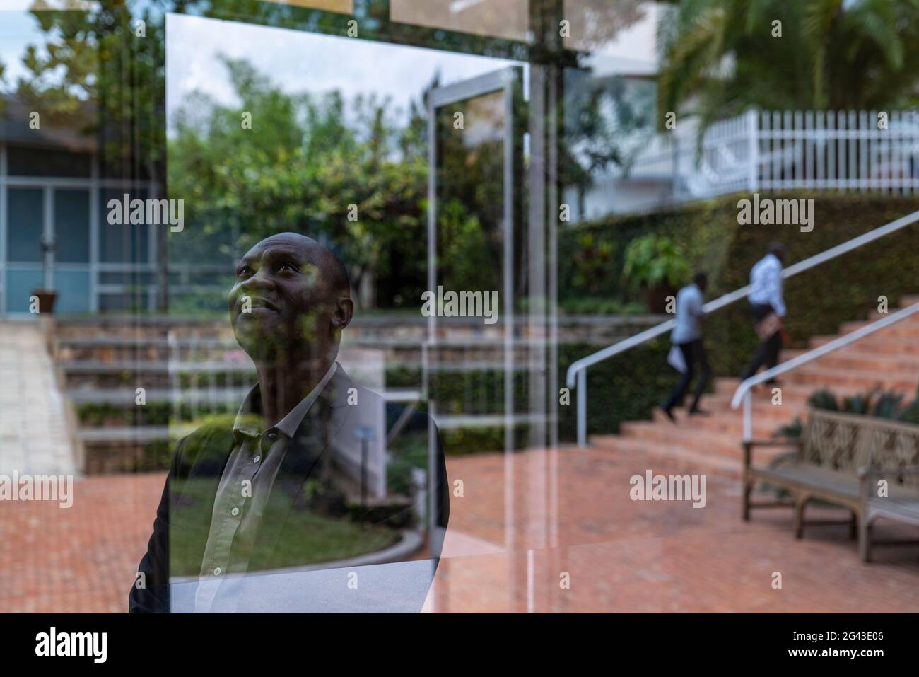 Nachdenklicher ruandischer Mann und Reflexion im Fenster des Kigali Genozid-Gedenkzentrums, Kigali, Provinz Kigali, Ruanda, Afrika Stockfoto