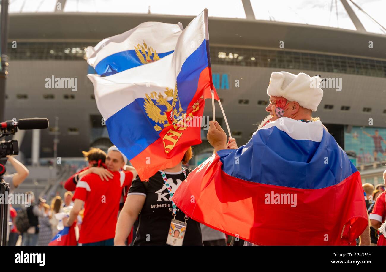 Männlicher Fan der russischen Fußballmannschaft gewickelt und hält Flagge, Gesicht bemalt, feiert den Sieg in Finnland-Russland Spiel, St. Petersburg, Russland Stockfoto