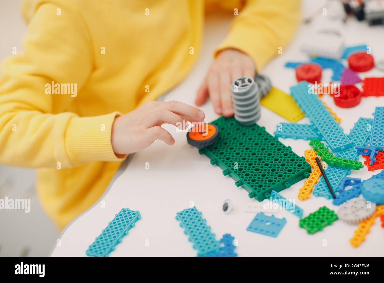 Lächelndes Kind Kind Konstruktor Überprüfung technisches Spielzeug. Kinder Robotics Konstruktor montieren Roboter. Stockfoto