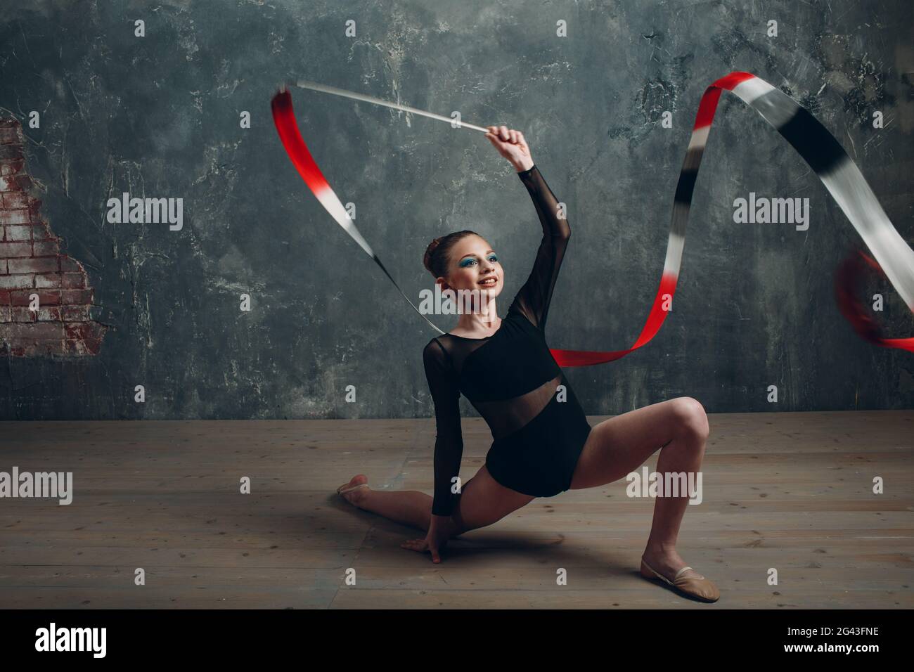Junge Mädchen professionelle Turnerin Frau rhythmische Gymnastik mit Band im Studio Stockfoto