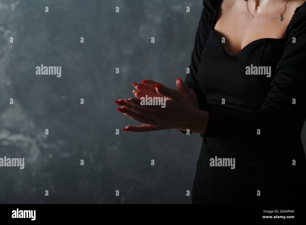 Frau in schwarzem Kleid klatscht in die Hände. Herzlichen Glückwunsch und Beifall. Stockfoto